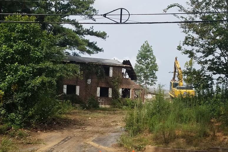 A bulldozer tears through a building of the Bolton Road Apartments in Atlanta